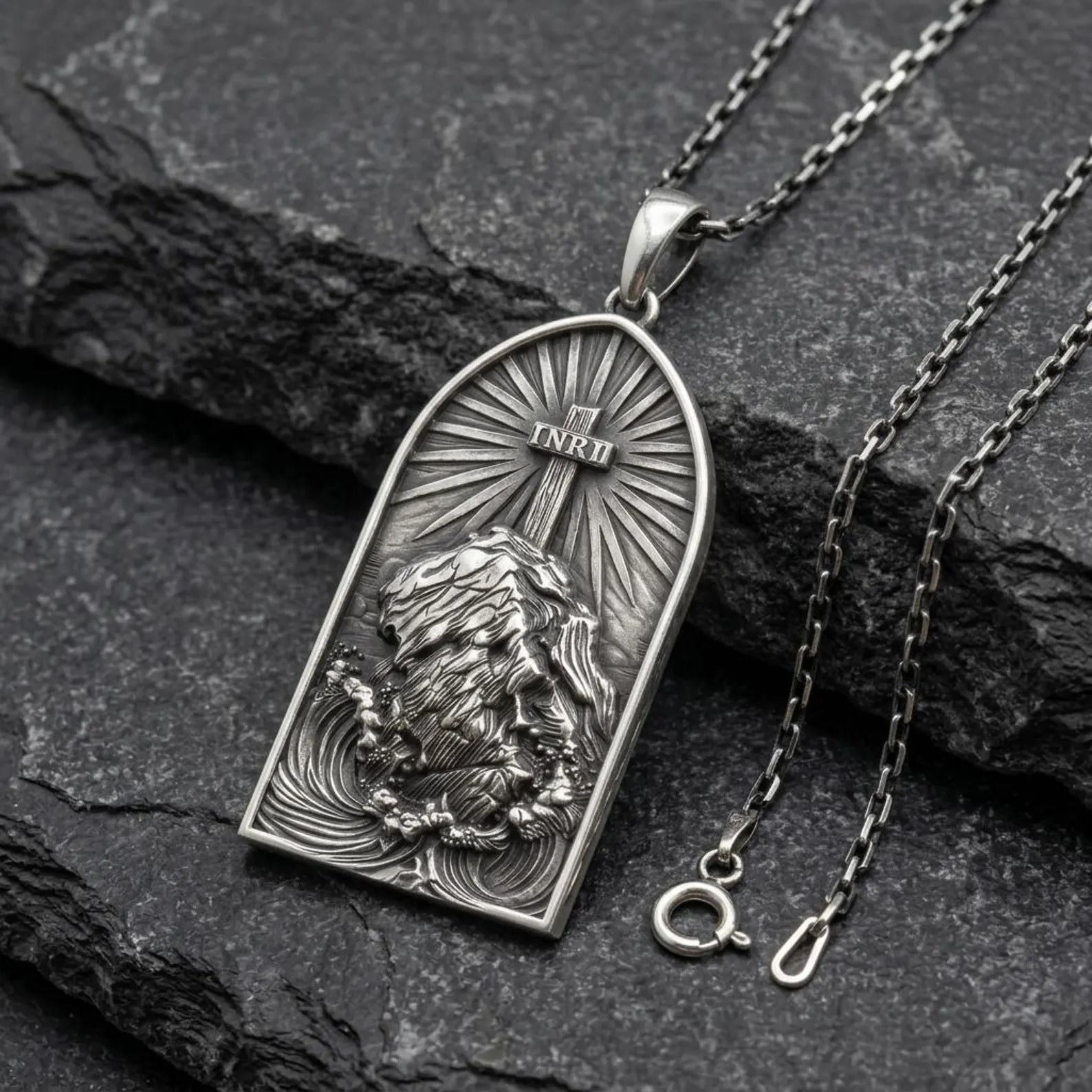 Close-up view of oxidized silver INRI cross pendant highlighting intricate engraving details and powerful religious symbolism
