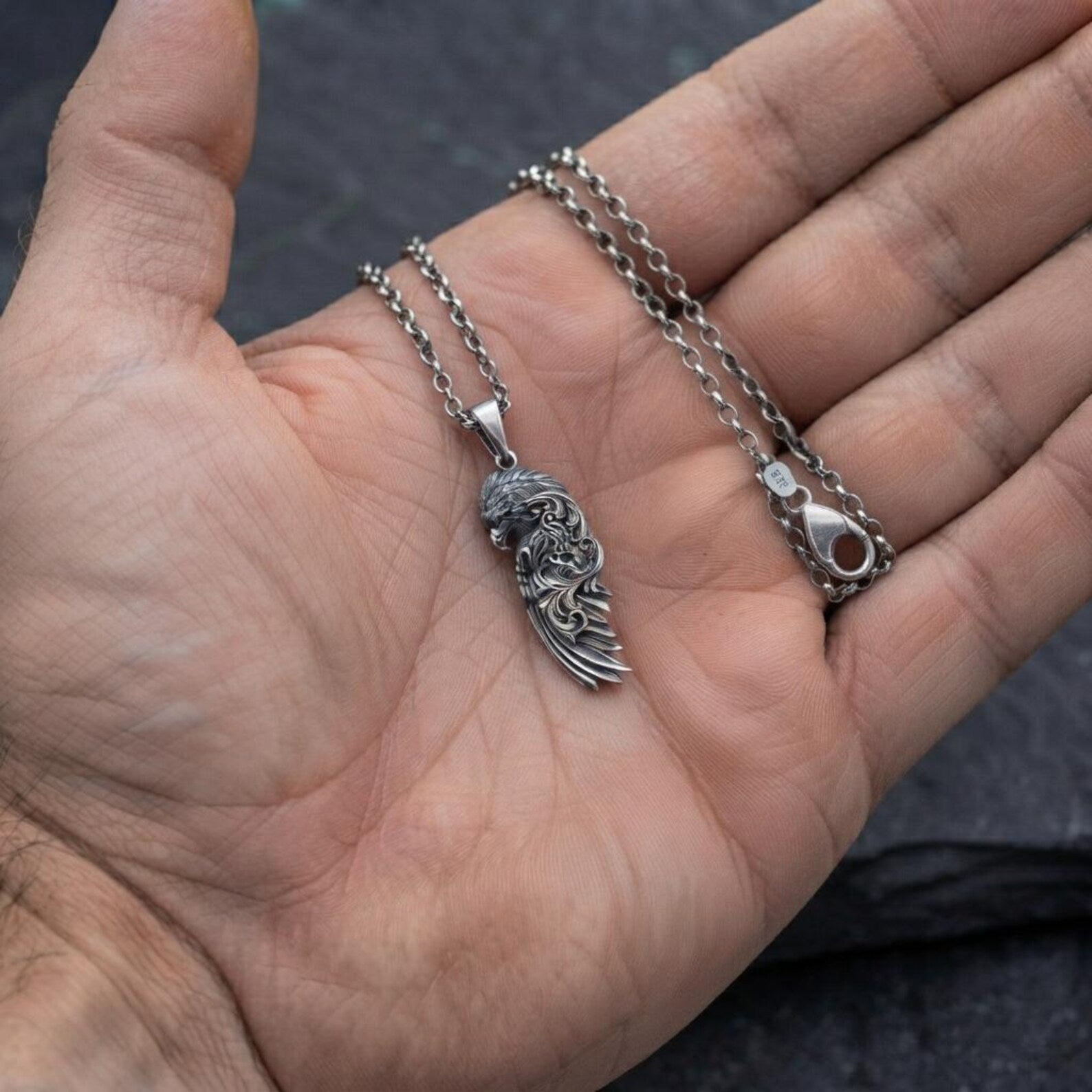Artisan-crafted sterling silver Raven Wing necklace inspired by ancient Norse mythology, featuring intricate Baroque decorative patterns, realistic feather engravings, oxidized antique finish, and bold handcrafted craftsmanship for everyday wear.