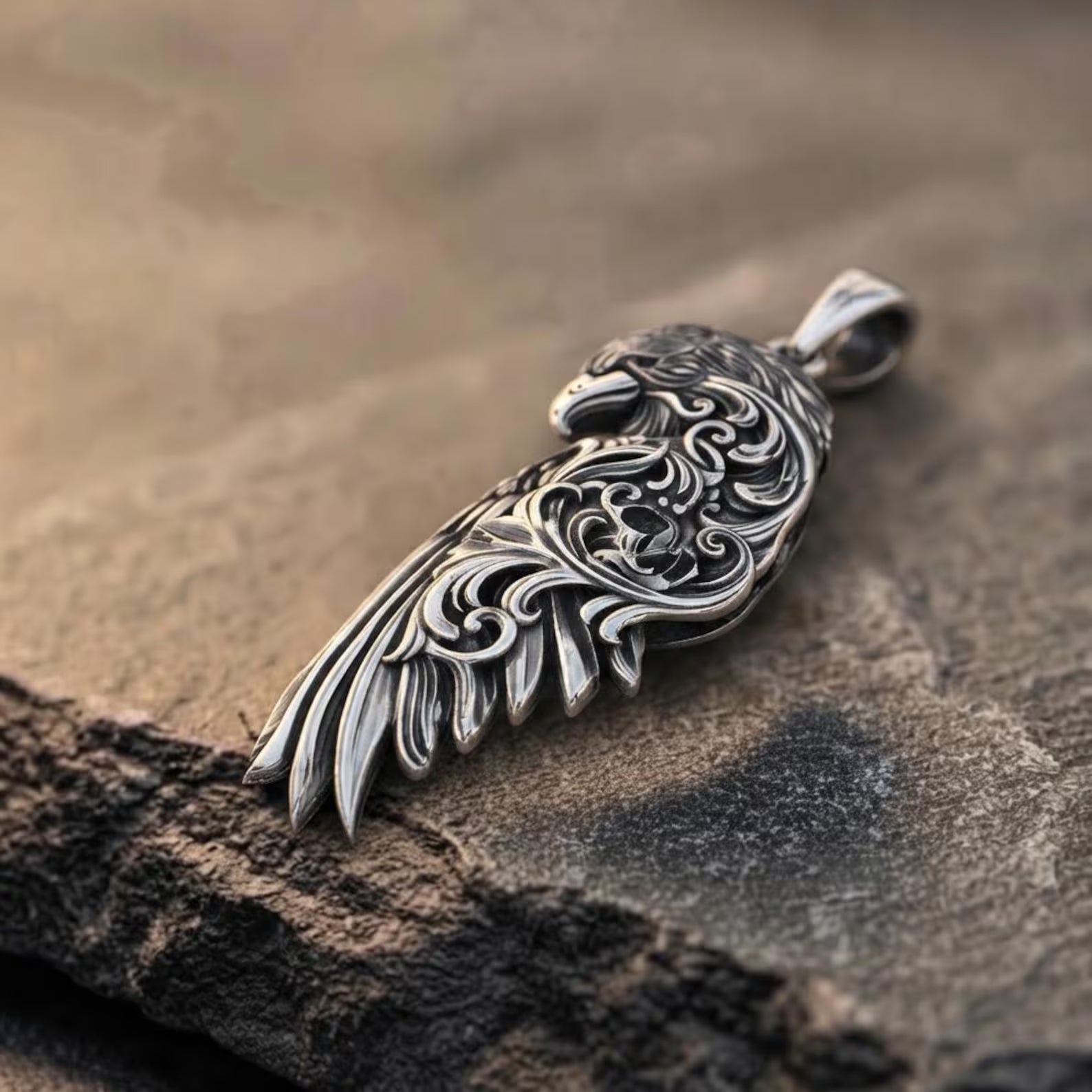 Premium sterling silver Raven Wing necklace featuring detailed feather engravings, decorative Baroque patterns, and a handcrafted oxidized finish that creates a bold mythological pendant inspired by Norse legends and timeless Gothic artistry.