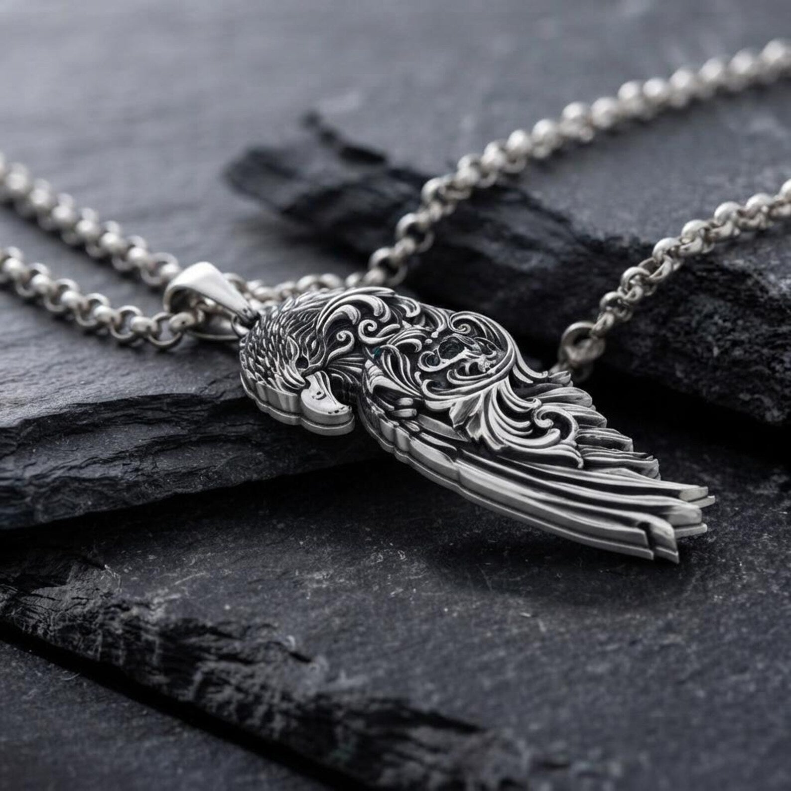 Men's handcrafted Raven Wing pendant necklace in genuine 925 sterling silver featuring elegant Baroque engravings, realistic feather textures, oxidized antique detailing, and exceptional craftsmanship inspired by Viking heritage and Norse mythology.